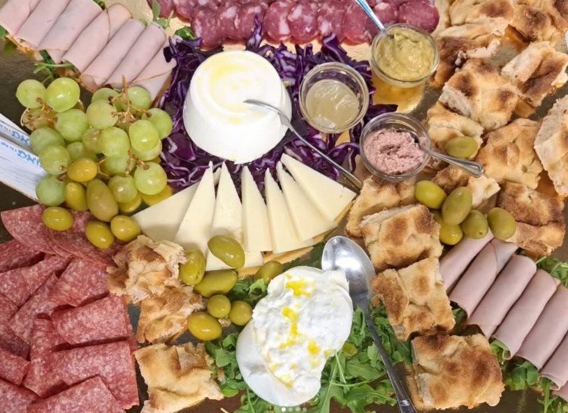 Tagliere con salame, prosciutto cotto, burrata, ricotta, formaggio a spicchi, olive, uva, focaccia e salse in vasetti